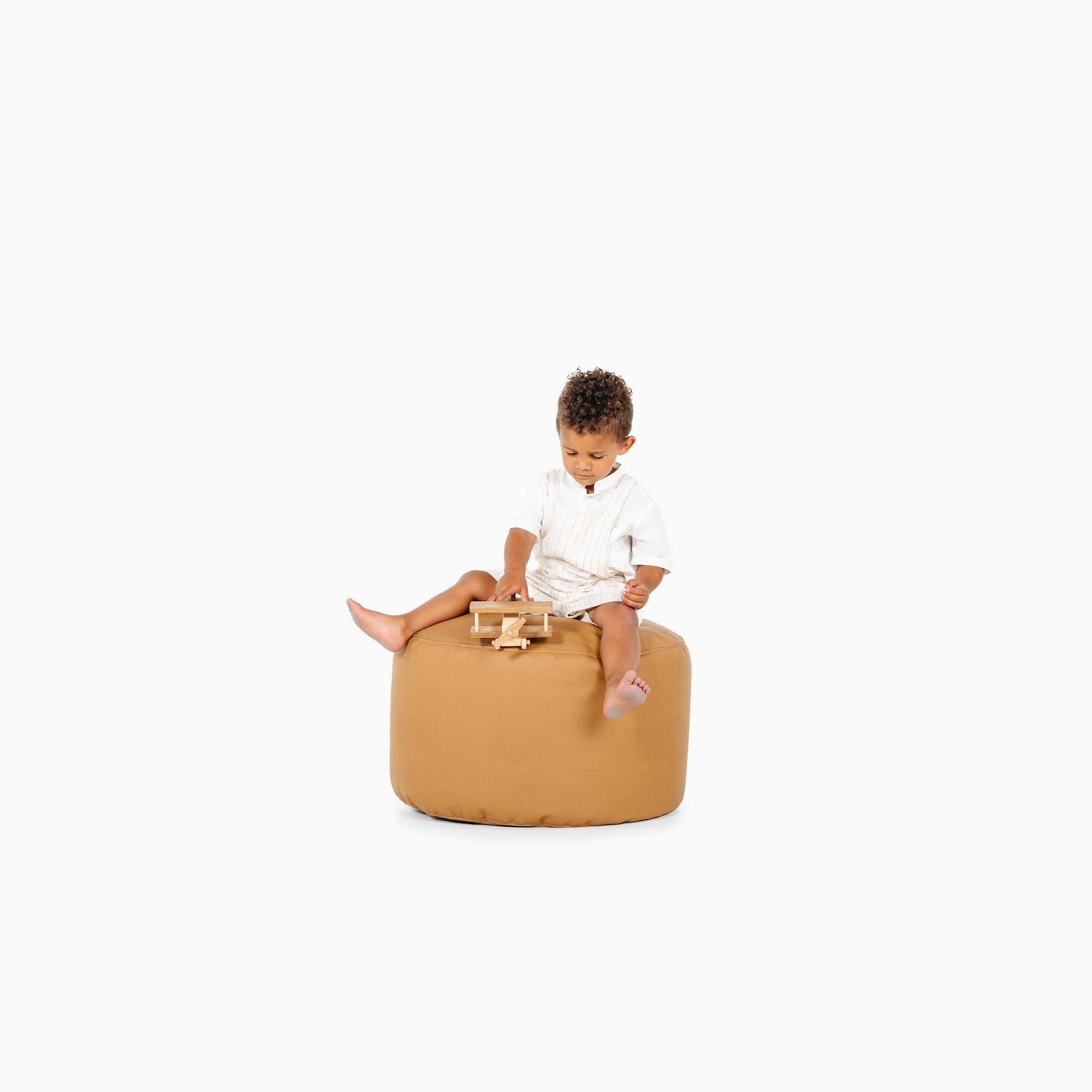 Camel@little boy sitting on the Camel Circle Pouf