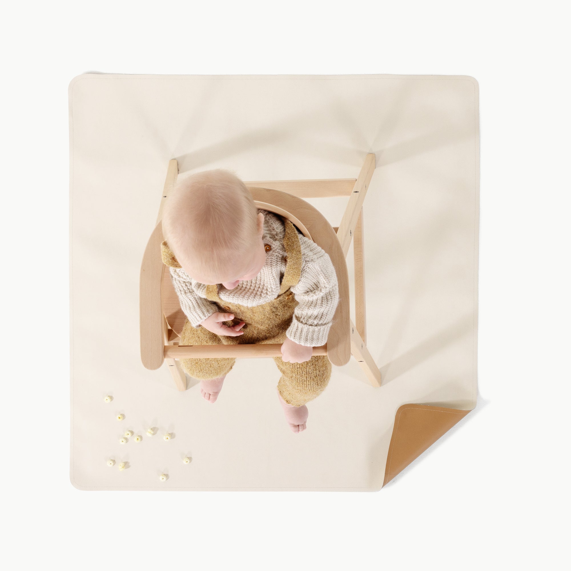 Camel • Ivory (on sale)@overhead of baby in a high chair on mini mat