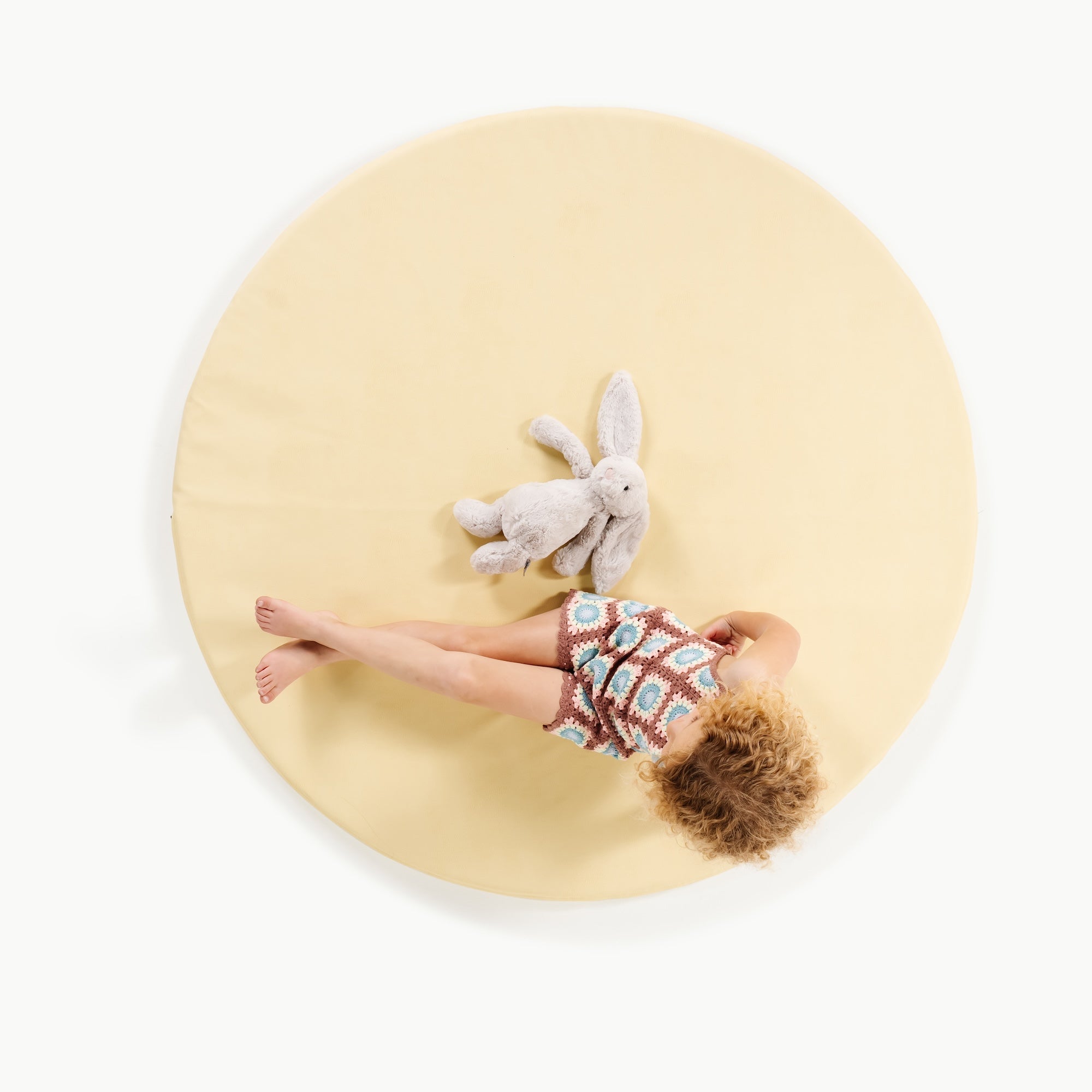 Mellow (on sale)@overhead of little girl sitting on padded mat