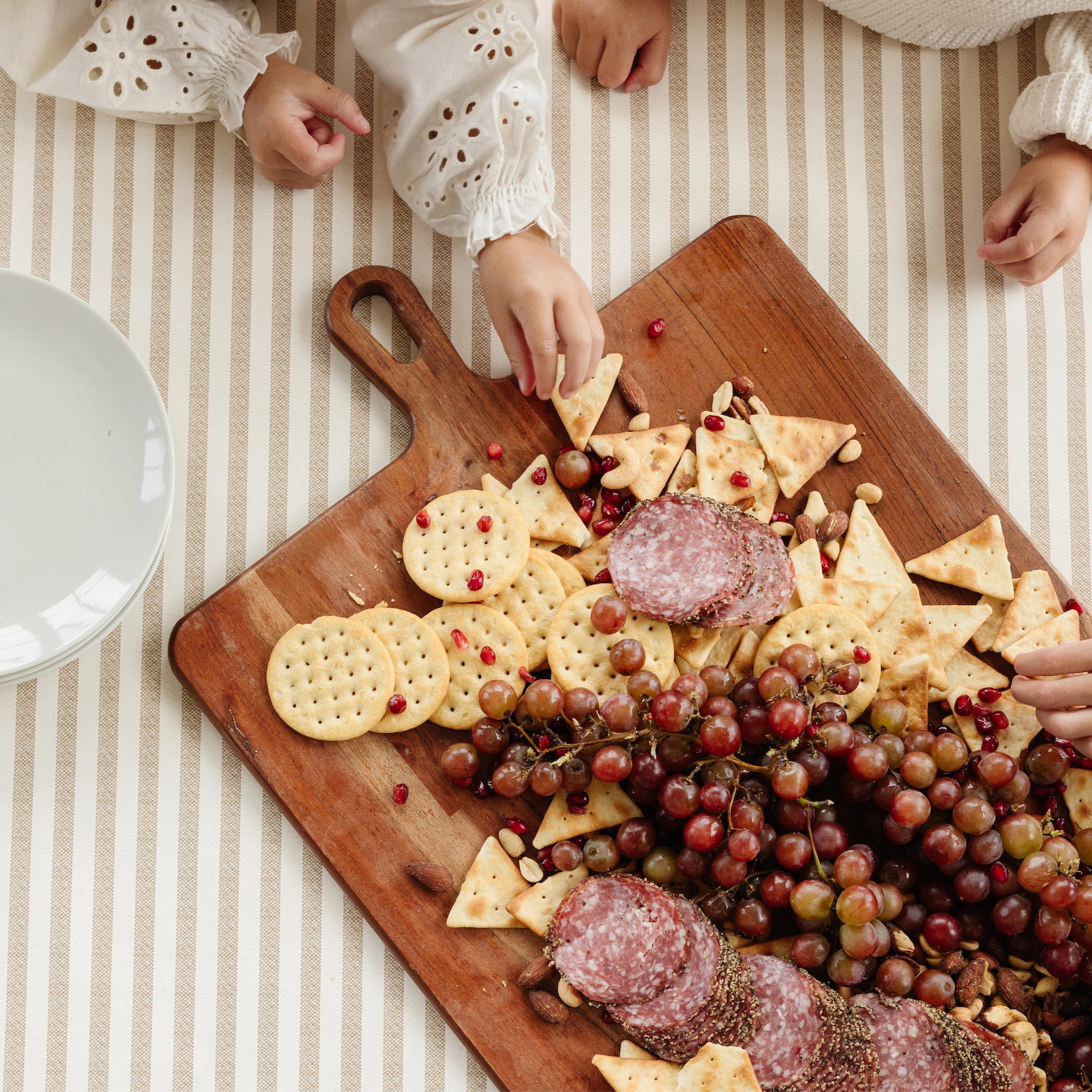 Cafe Stripe@Kids reaching for snacks on Cafe Stripe tablecloth