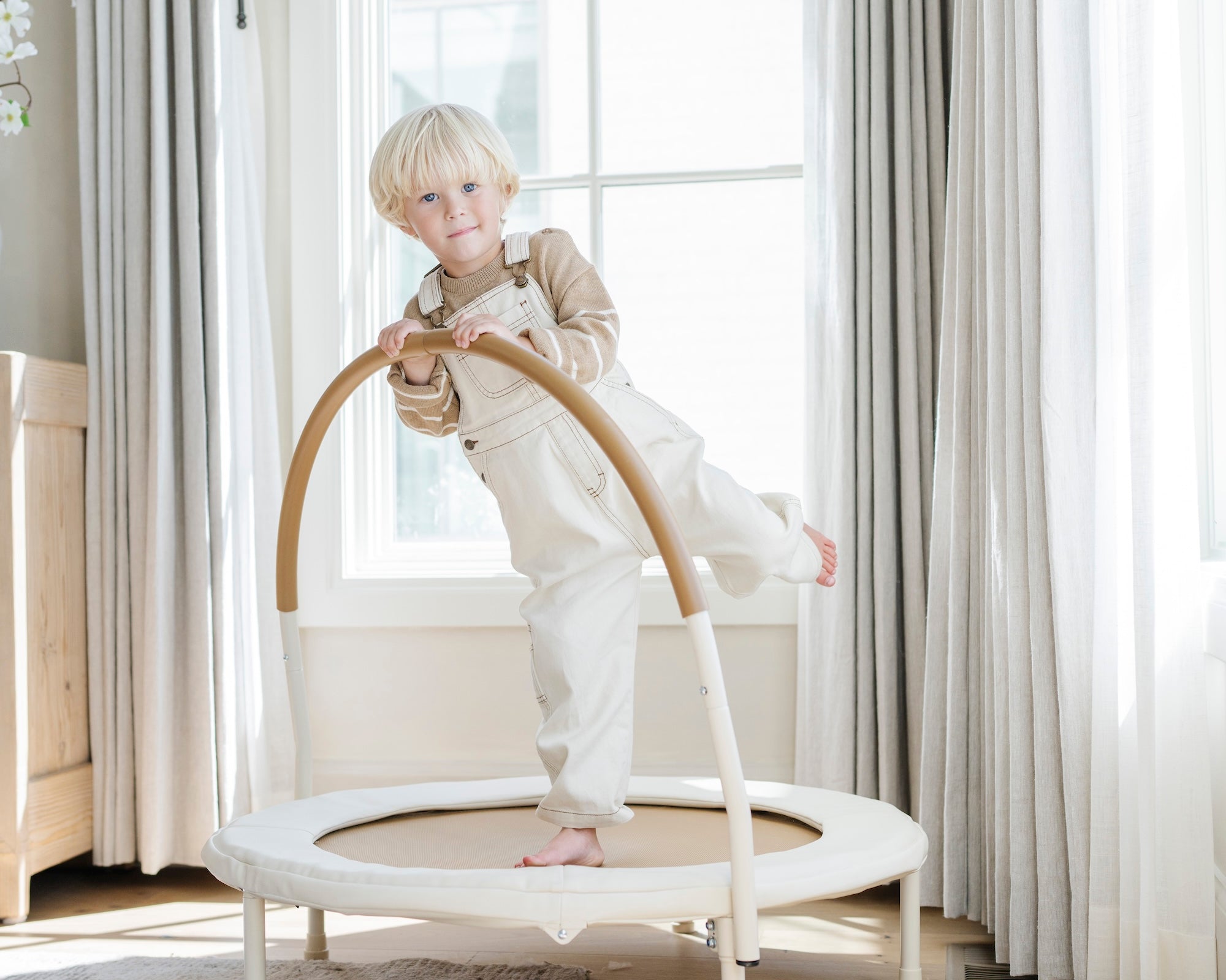 Ivory / Classic@Child using a low-profile indoor trampoline designed for balance and movement