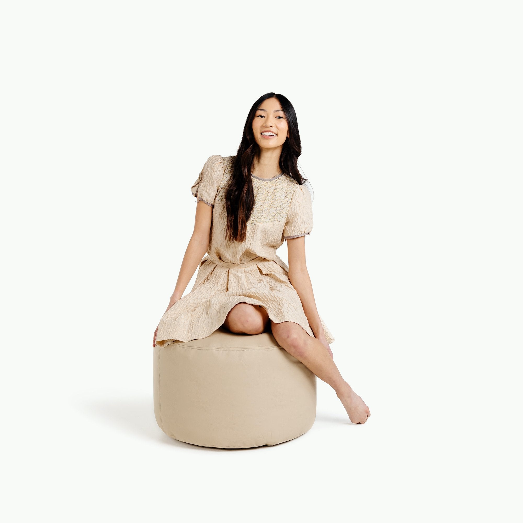 Millet@woman sitting on the Millet Circle Pouf