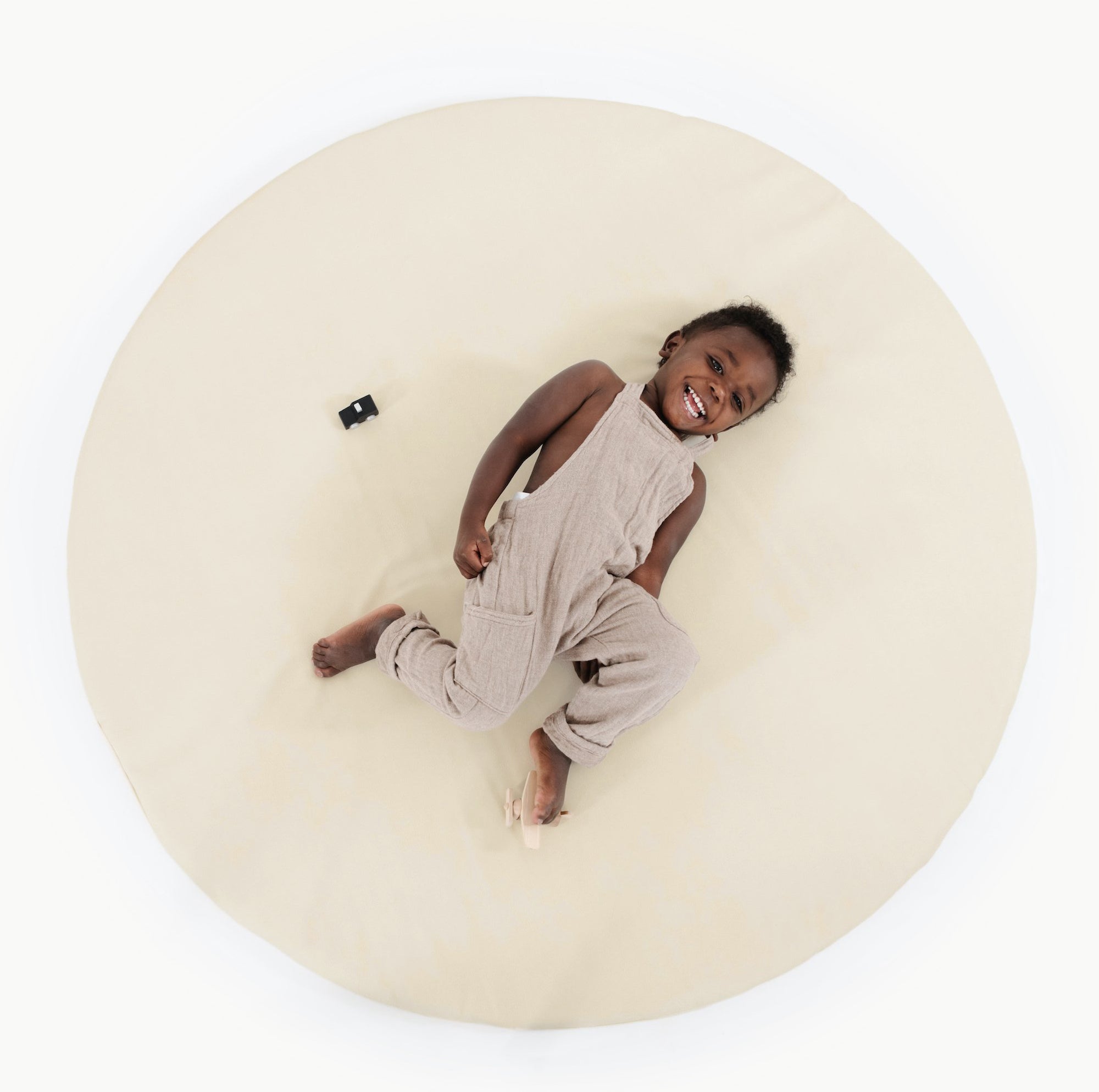 Blanc (on sale)@overhead of kid playing on the blanc padded midi circle