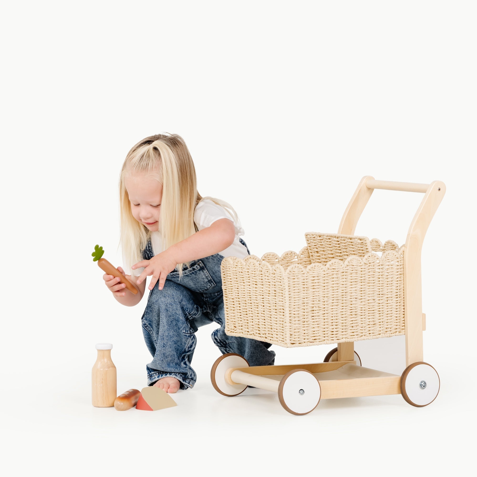 kid putting the grocery set into the shopping trolley