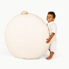 Ivory / Circle@Olittle boy holding the Ivory Circle Floor Cushion