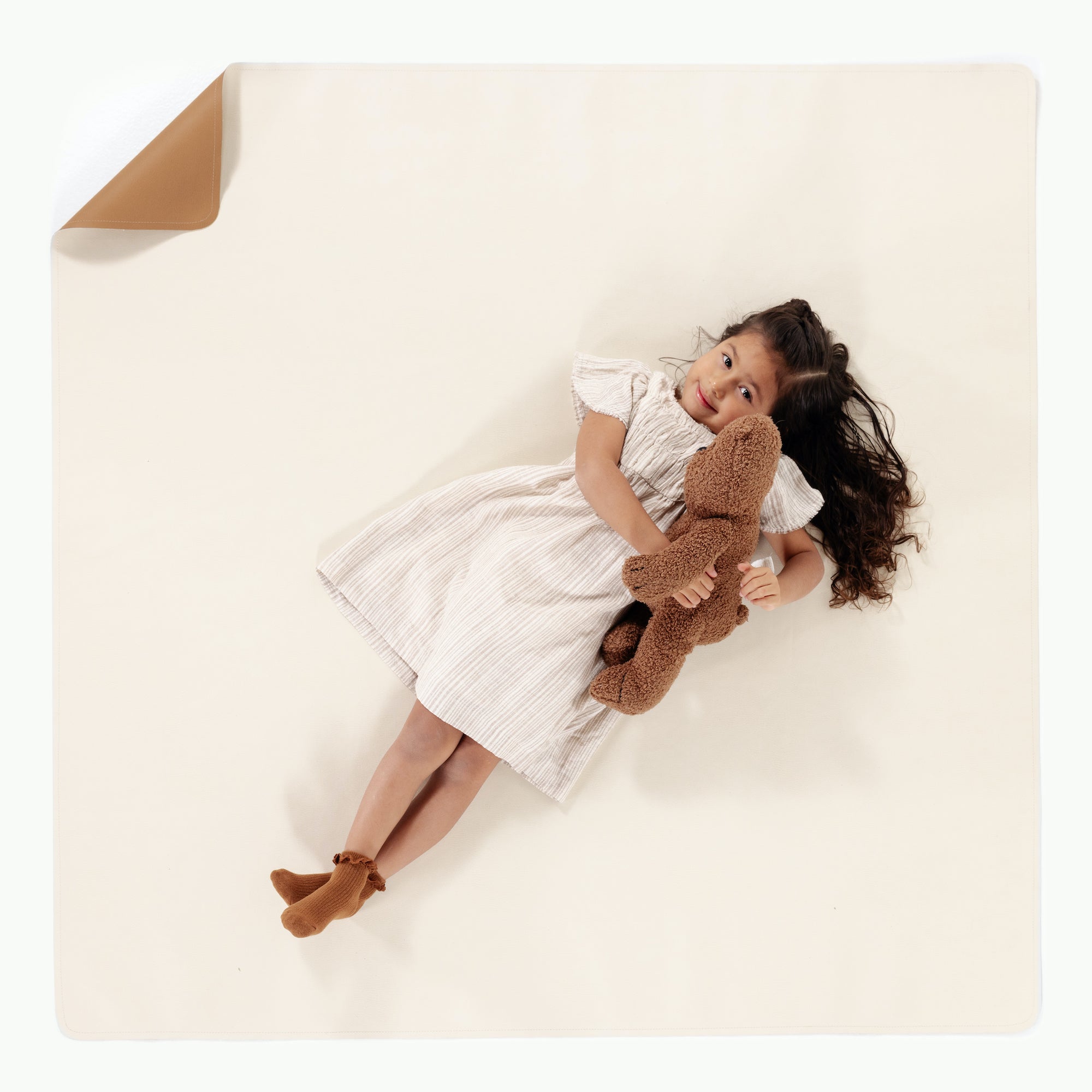 Camel • Ivory / Square@overhead of little girl sitting on mat