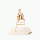 Camel • Ivory (on sale)@baby in a high chair on top of a mini mat