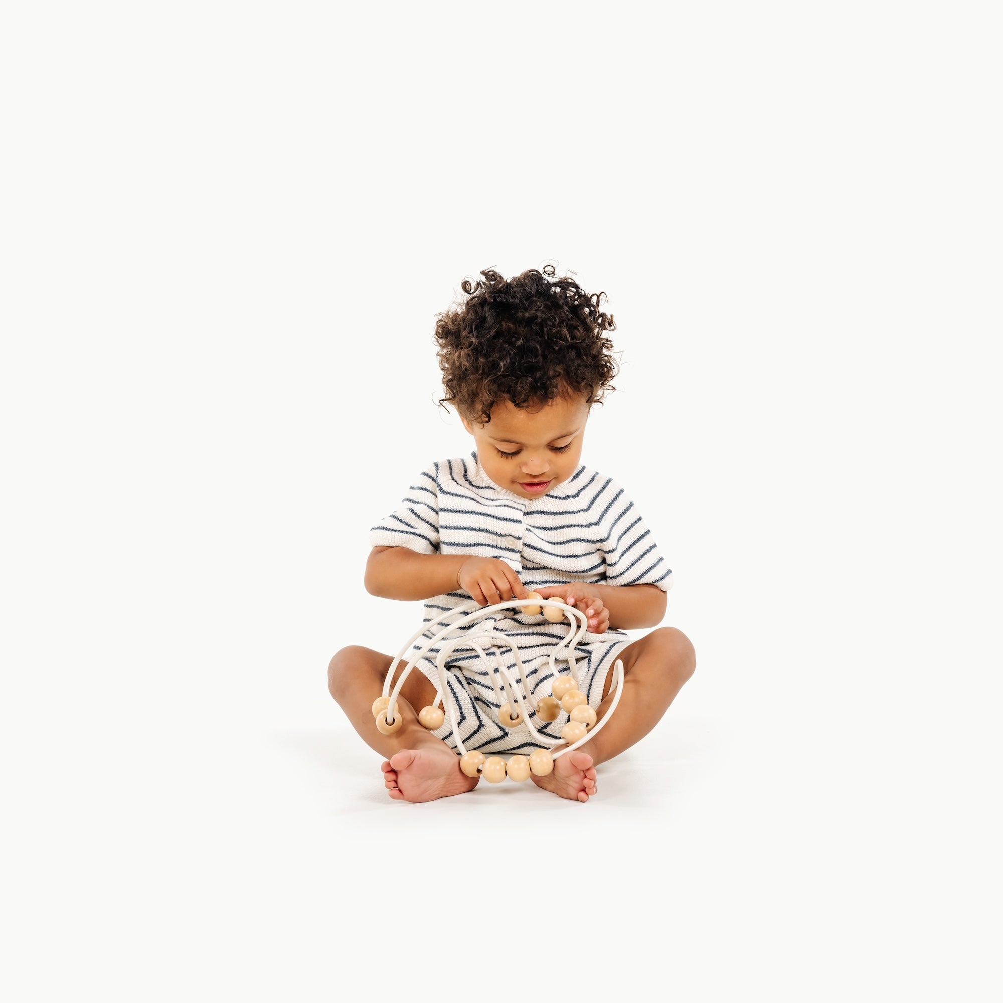 Ivory / Circle@Baby engaging with bead maze to build hand-eye coordination