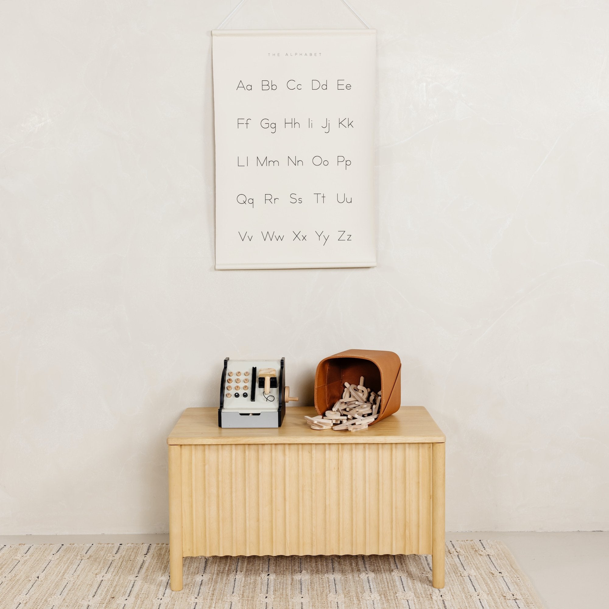 Alphabet@Alphabet Poster hanging on wall above a toy chest