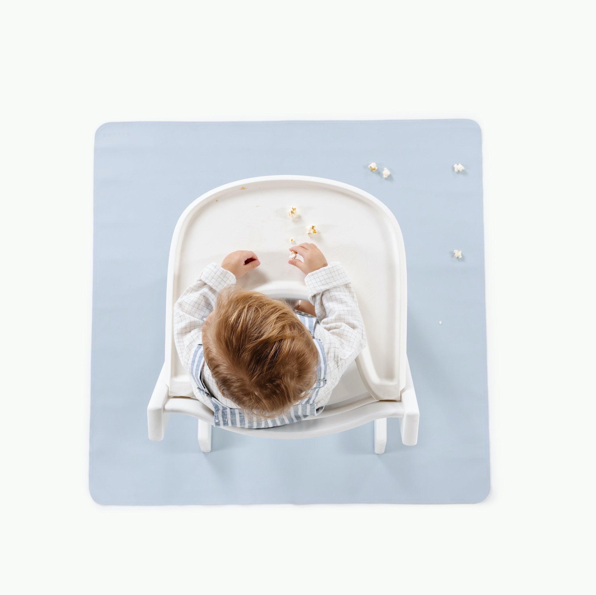 Beau@Overhead baby in a highchair sitting on the Beau Mini Mat