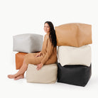 Camel@Woman sitting on a Square Pouf surrounded by other Square Poufs 