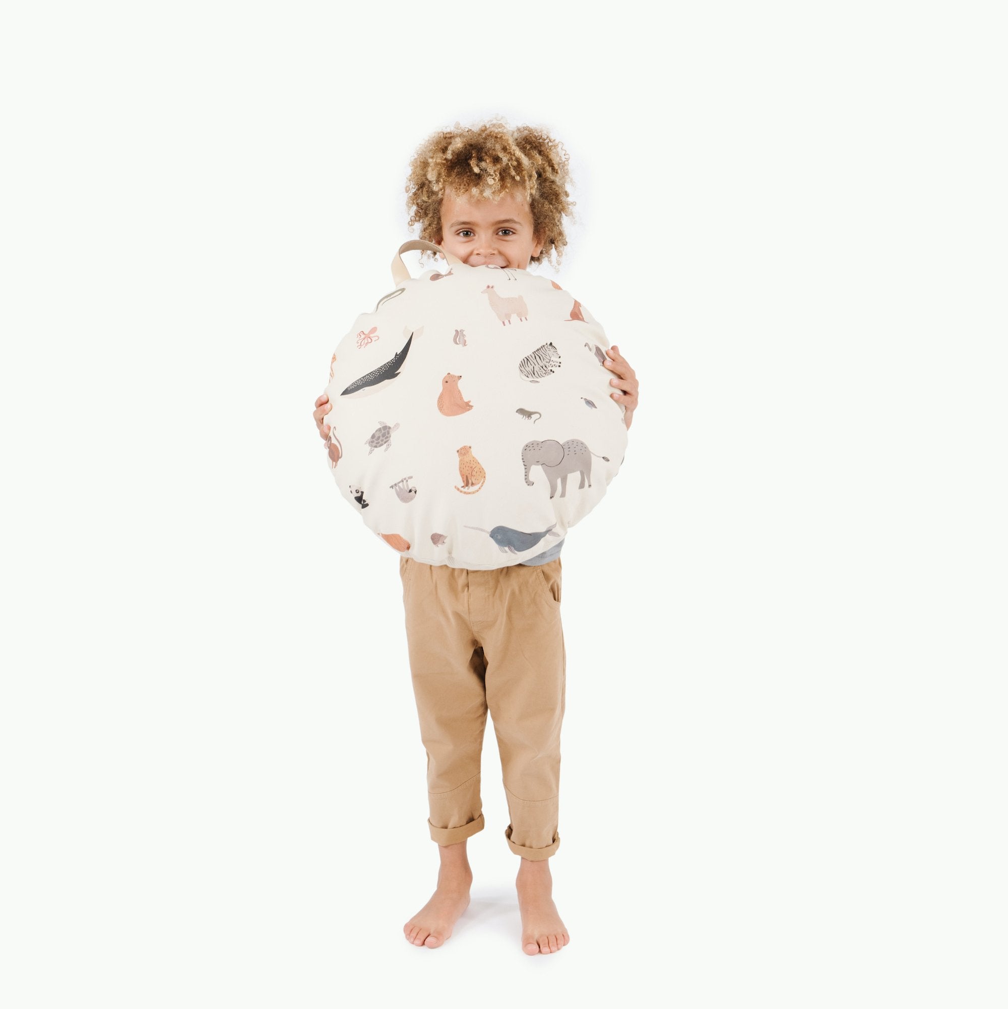 Menagerie (on sale) / Circle@Kid holding the Menagerie Mini Circle Floor Cushion