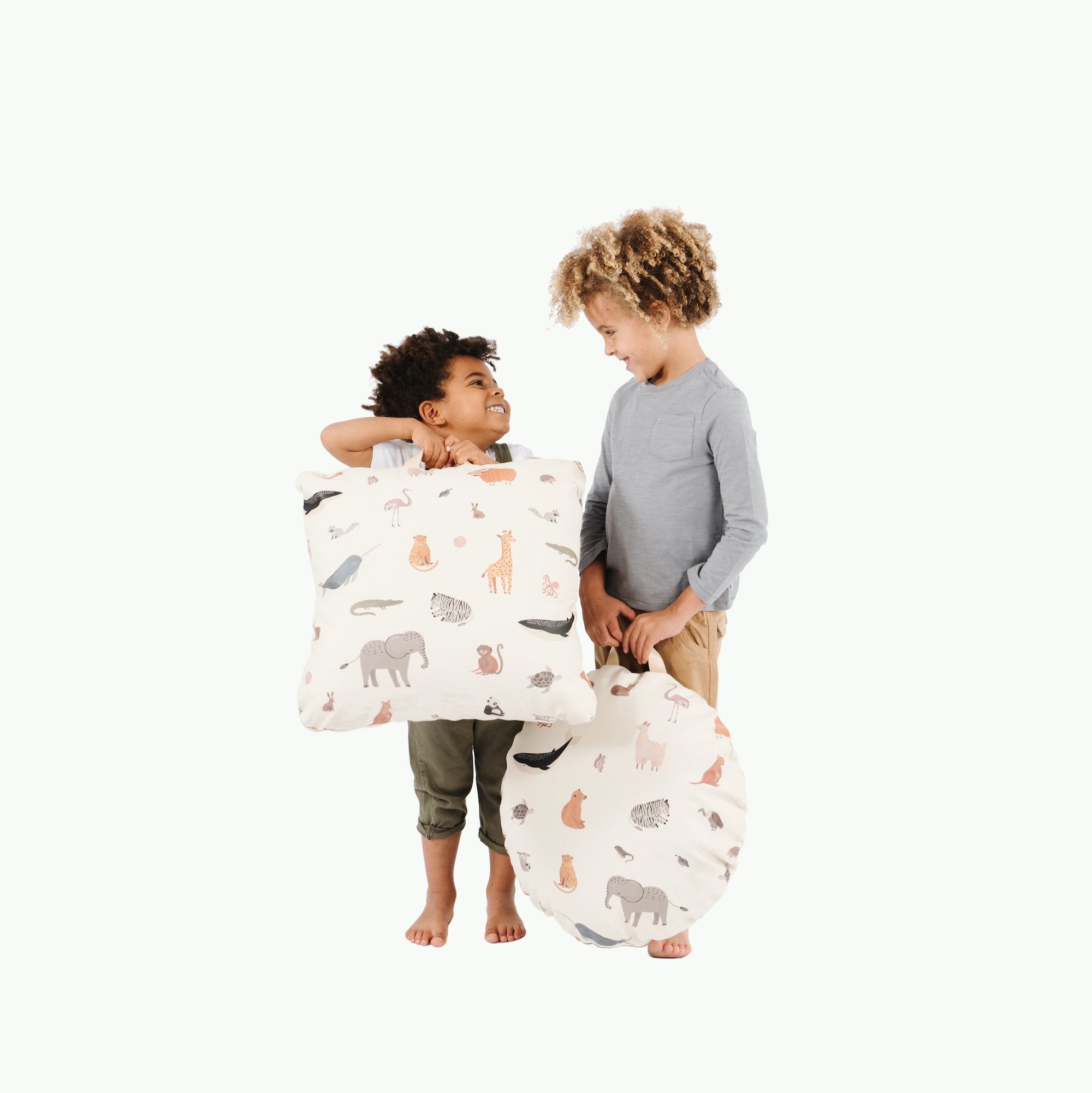 Menagerie (on sale)@Kid holding the Menagerie Mini Floor Cushion