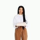 Pebble@Woman holding folded Pebble Midi+ Mat in white Gathre packaging