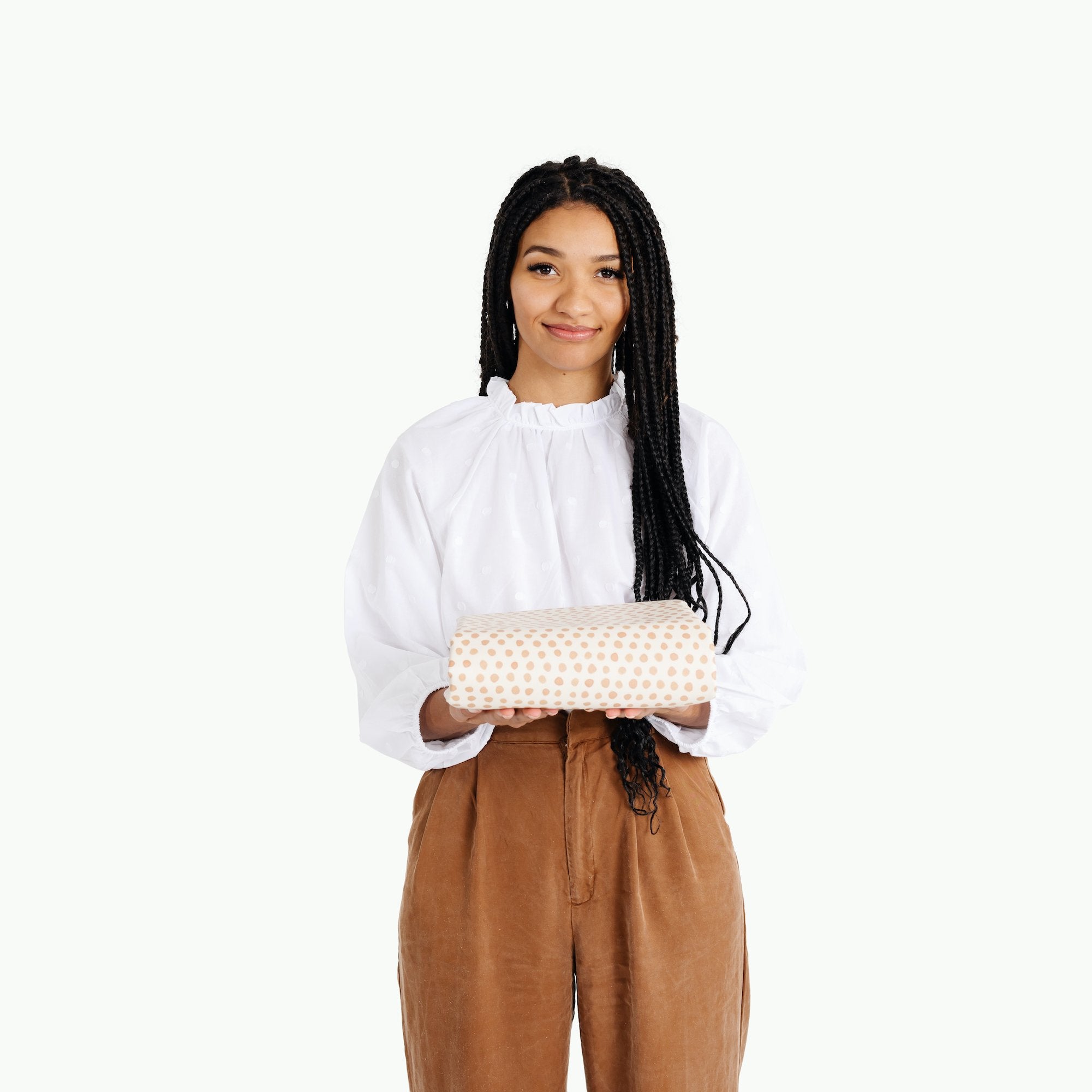 Pebble@Woman holding folded Pebble Midi+ Mat in white Gathre packaging