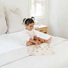 Peter Rabbit™ (on sale)@Lifestyle image of a little girl sitting on a Peter Rabbit™ micro mat