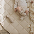 Ivory / Circle@overhead of baby on a quilted mini mat